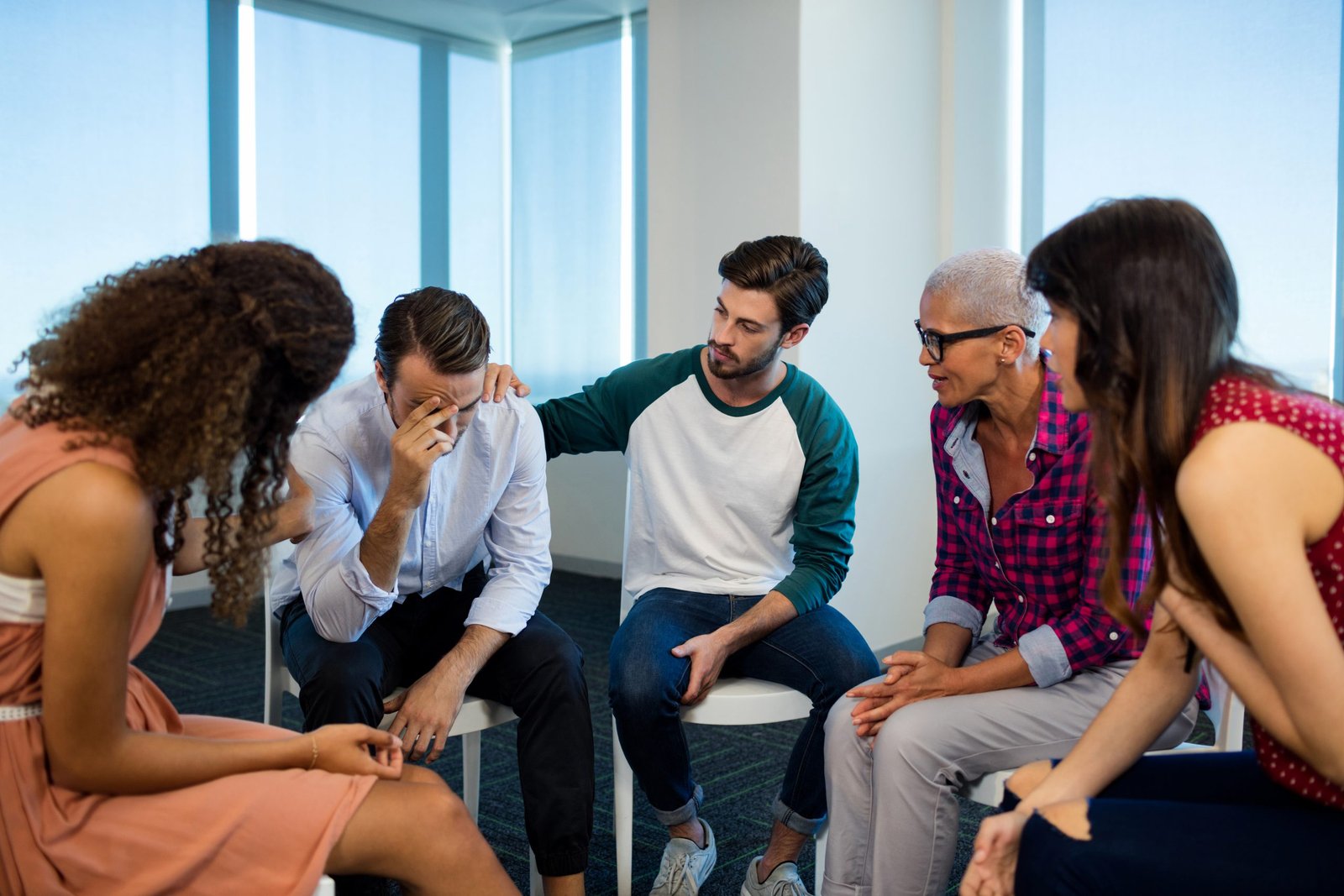 Creative business team consoling upset colleague at office