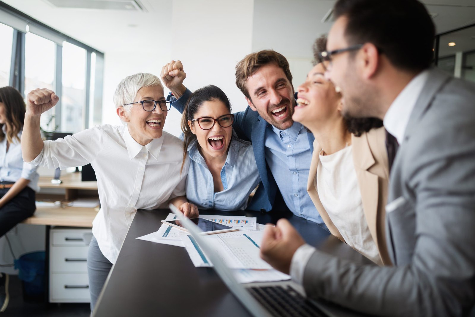 Happy business people celebrating success at modern company